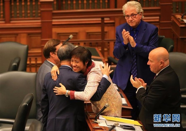 10月26日，在加拿大多倫多，安大略省議會議員黃素梅（中）與同事擁抱慶祝動議獲通過。（新華社 鄒崢攝）