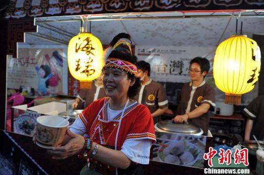 10月26日晚，一位身穿台灣阿美族服飾的阿嬤在向民眾推介美味的台灣小吃