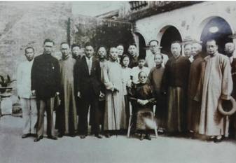 1935年，辛亥武昌起義志士喻育之等參觀孫中山故居時與孫妙茜合影（坐著為孫妙茜，左七為喻育之）