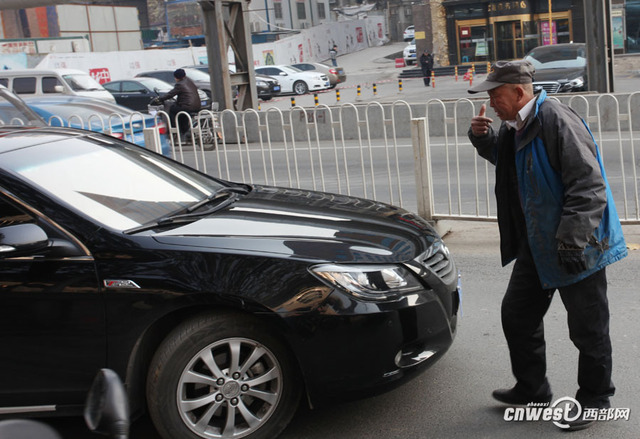 西安一男子馬路上強行攔車給錢才放行