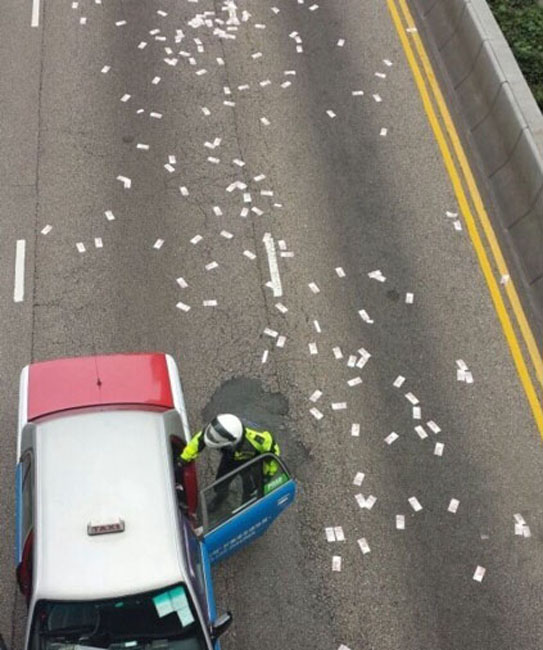 香港運鈔車錢箱跌出車外大量紙幣散落 民眾撿拾