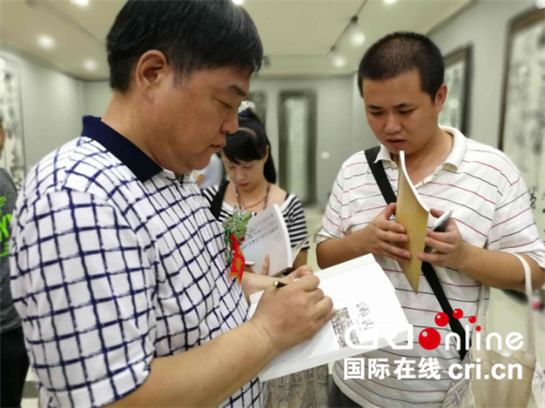 “馬河聲書畫展”在西安雁塔美術館開幕 展出作品50余件_fororder_開幕式現場，馬河聲為很多書畫愛好者簽名並寫祝福語（梁明 攝）_副本