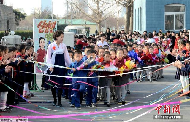 朝鮮學生手捧花束佩戴大紅花迎接新學期