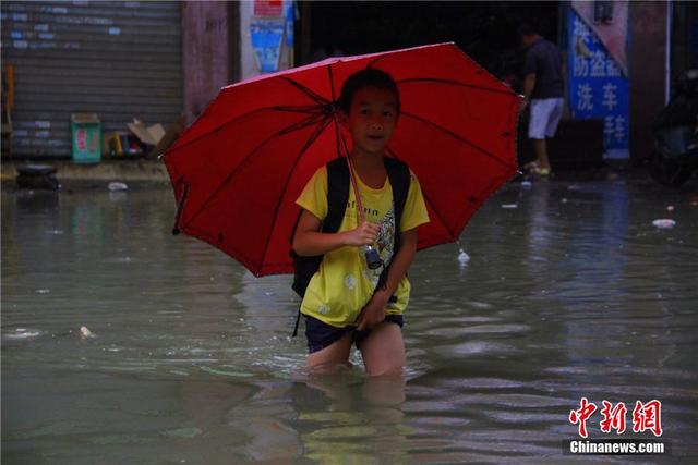 廣西暴雨致街道積水過膝 民眾涉水送子上學