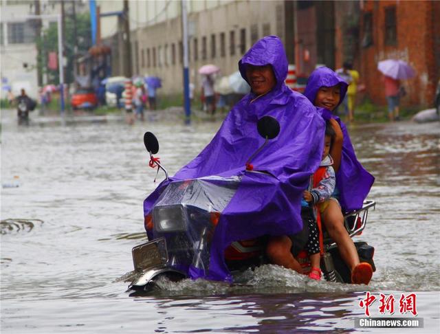 廣西暴雨致街道積水過膝 民眾涉水送子上學