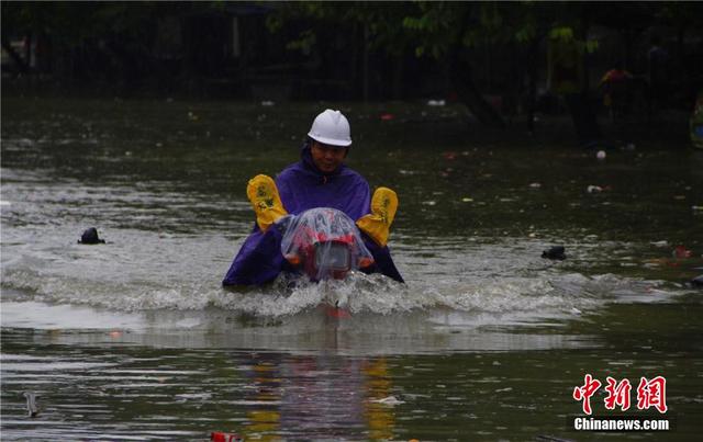 廣西暴雨致街道積水過膝 民眾涉水送子上學