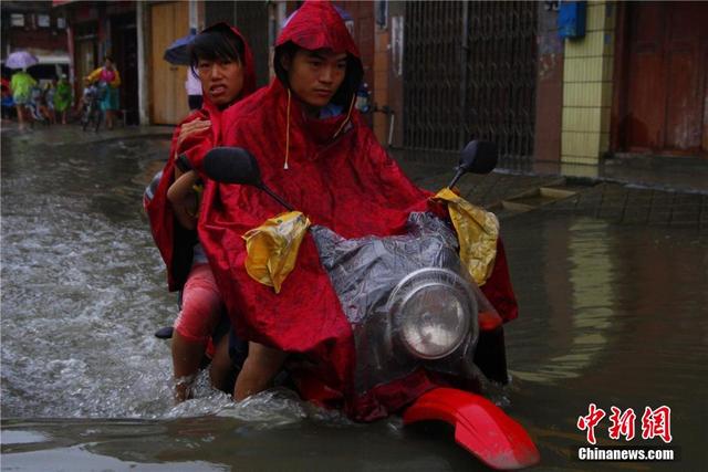 廣西暴雨致街道積水過膝 民眾涉水送子上學