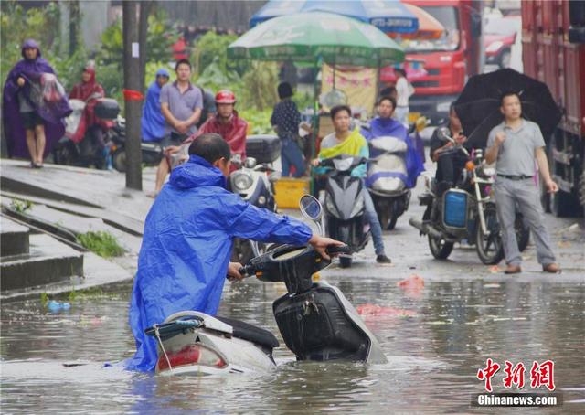 廣西暴雨致街道積水過膝 民眾涉水送子上學