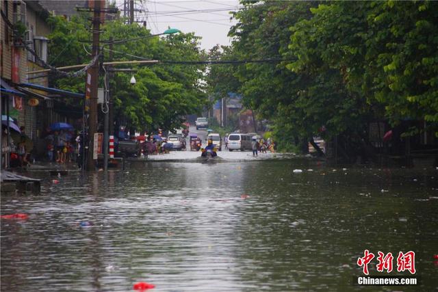 廣西暴雨致街道積水過膝 民眾涉水送子上學