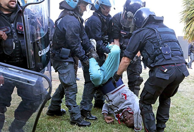 意大利警察將非法移民強行拖上大巴