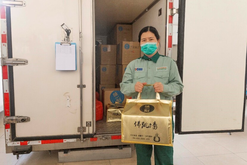 廣州企業為留穗過年員工準備了現金紅包_fororder_彭鵬提著要給家裏寄去的佛跳墻