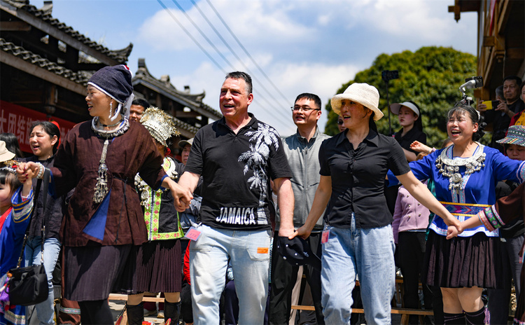 吹蘆笙彈琵琶歌慶“祭薩節” 中外遊客探秘廣西龍勝原生態民族文化_fororder_3月24日，在廣西桂林市龍勝各族自治縣樂江鎮寶贈村，侗族民眾與遊客在歡跳多耶舞。 (1).JPG