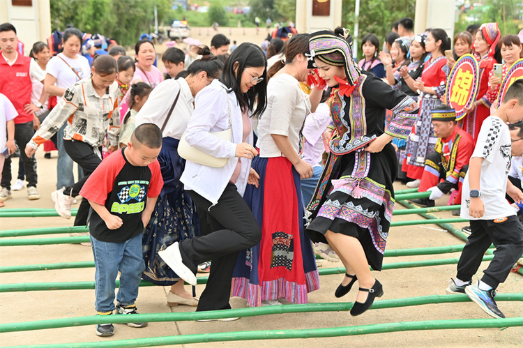 【潮起三月三】廣西象州：妙皇三月三茶旅文化活動點“燃”鄉村旅遊新爆點_fororder_遊客在體驗跳竹竿舞.JPG