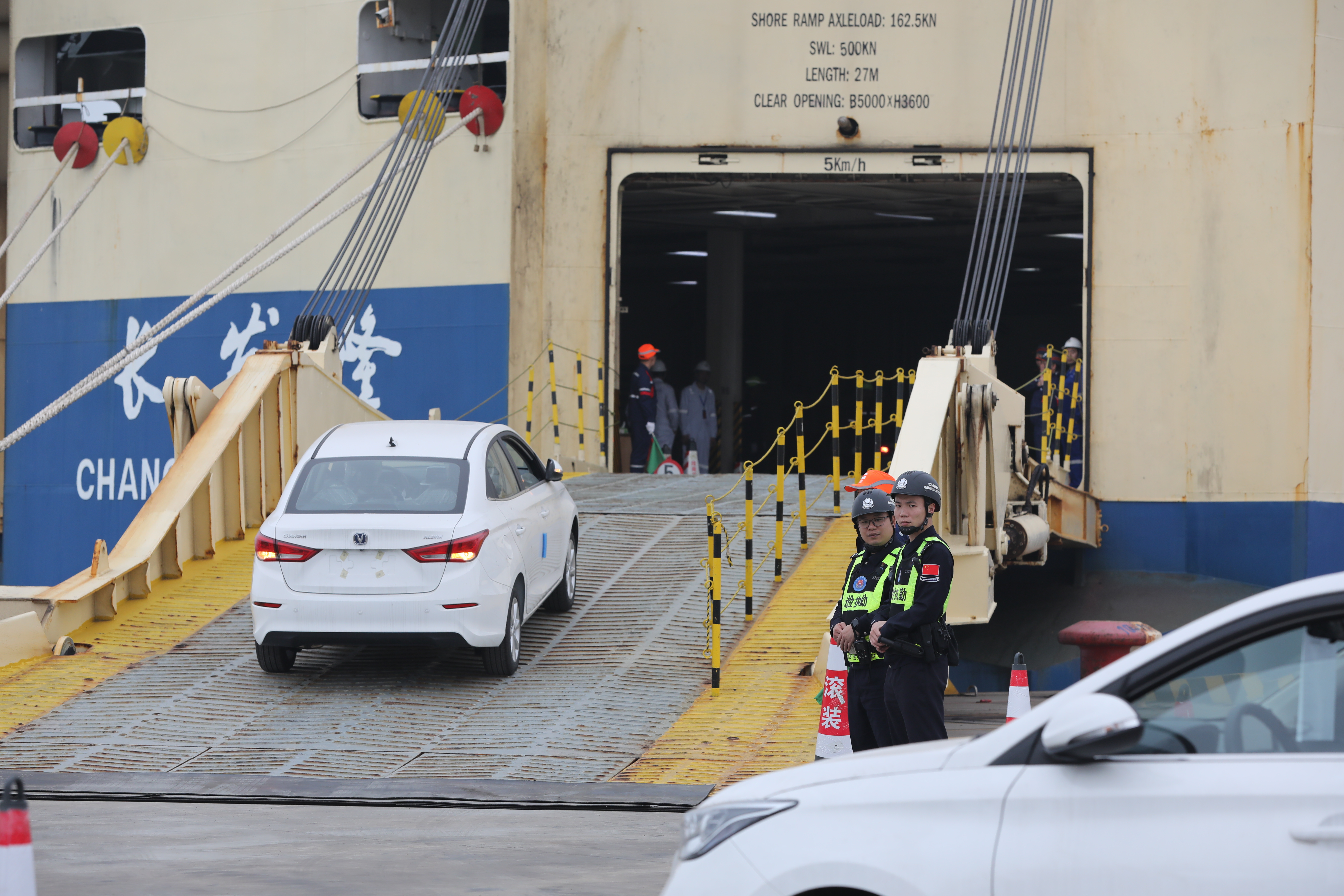 國産汽車乘“新通道”快車出海 邊檢跑出通關“加速度”_fororder_圖為移民管理警察在滾裝船船閘口安全監護2.JPG