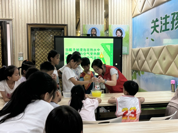 廣西興業：多彩文明實踐 護航孩子快樂成長_fororder_小朋友在志願者的協助下進行科學小實驗