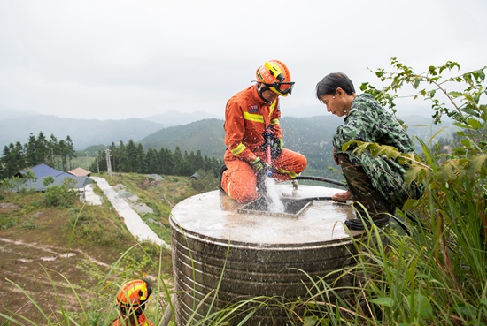 貴州天柱全力“抗旱搶收”保民生_fororder_天柱縣消防救援隊隊員送水到藍田鎮公閃村養殖戶家。