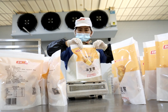 貴州龍裏：加緊擴能生産 食品保供有保障_fororder_員工在貴州龍包裝豆類製品。.JPG