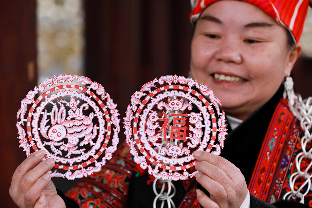 貴州劍河：生肖剪紙賀新年_fororder_1月17日，國家級非物質文化遺産苗族剪紙傳承人姜文英在劍河縣華潤希望小鎮展示剛剪的“福兔”窗花。（吳昌連 攝）.JPG