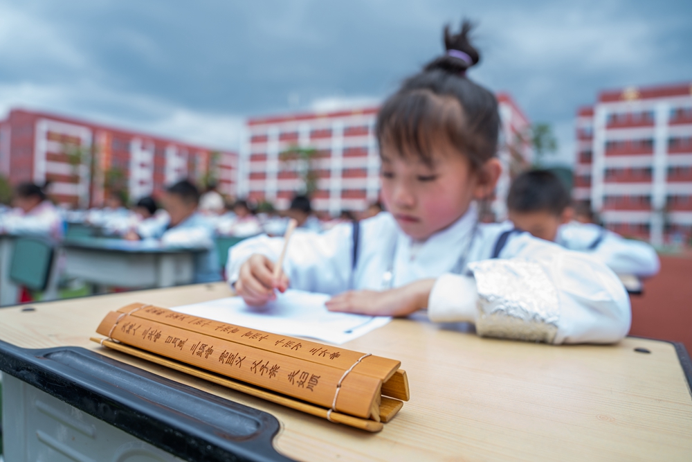 貴州畢節：誦“國學” 展“國韻”_fororder_2023年5月12日，學生們在貴州省畢節梁才學校操場上參加書寫漢字古文活動。  (2)