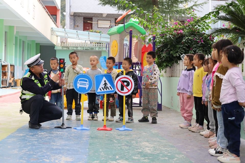 貴州鎮遠交警走進幼兒園 帶著萌娃學安全_fororder_圖1：圖為民警教小朋友識別交通標誌標識。.JPG