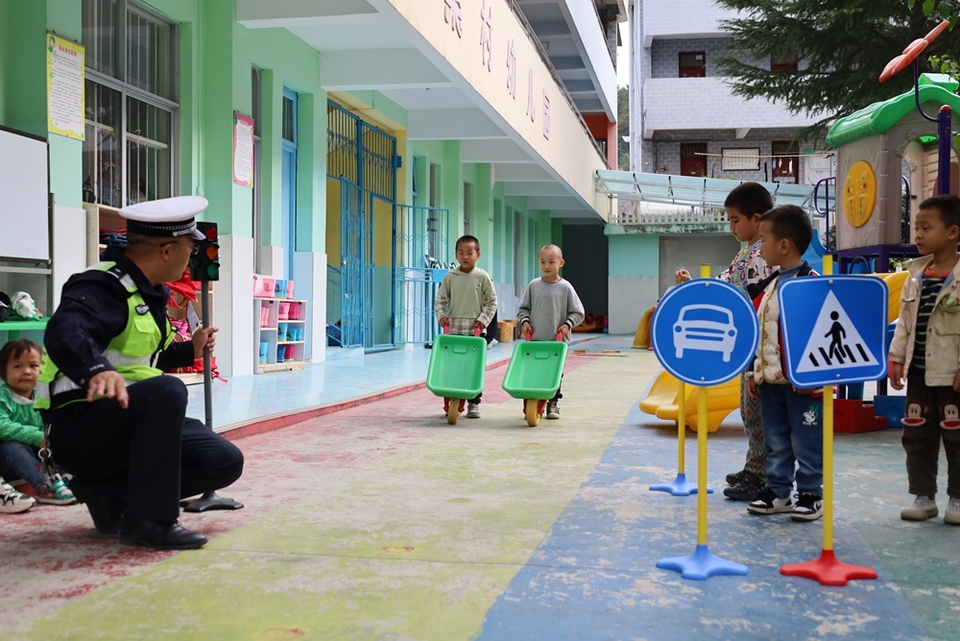 貴州鎮遠交警走進幼兒園 帶著萌娃學安全_fororder_圖4：圖為進行模擬行人車輛行人過馬路.JPG