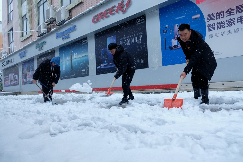 貴州天柱：幹群齊心 除雪保安全_fororder_縣融媒體中心幹部職工在縣文體廣電旅遊局門口掃除積雪。.JPG