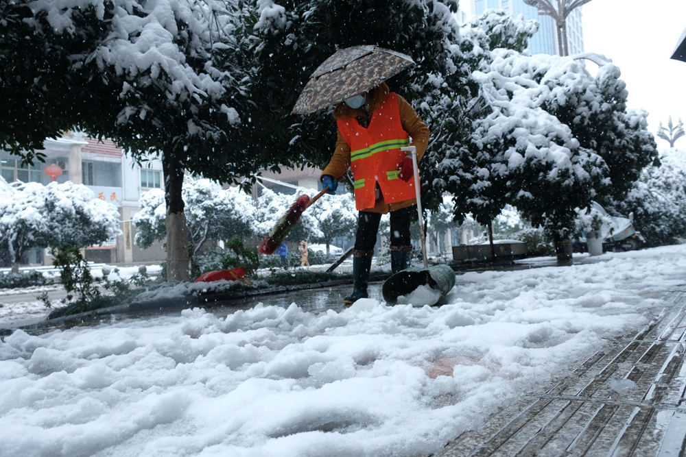 貴州天柱：幹群齊心 除雪保安全_fororder_清潔工人在貴州銀行門口清掃積雪。.JPG