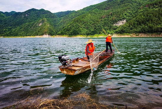 （供稿）貴州甕安持續推進烏江流域水生態文明建設_fororder_甕安縣珠藏鎮豐岩村村民盧錫永、冉戌英夫婦駕駛小船打撈江面垃圾（盧錫江 攝）