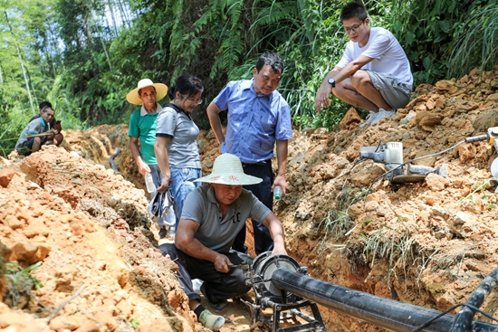 貴州天柱：探索建立湘黔兩省聯合幫扶工作機制_fororder_駐村幹部查看消防水池建設進度.JPG