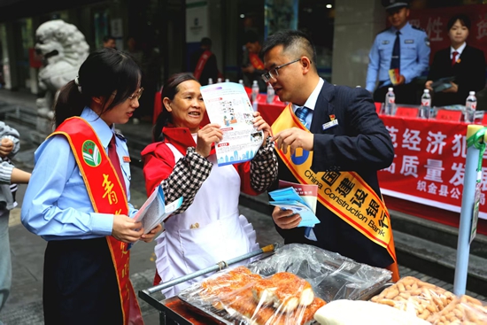 貴州畢節：多部門聯合開展打擊和防範經濟犯罪宣傳_fororder_圖為稅務人員在織金縣北大街建設銀行門口向過往人群宣傳。高莉佳攝