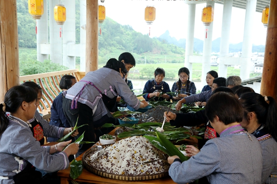貴州荔波：粽似飛鳥銜福至 濃情粽香祈安康_fororder_布依族婦女聚在一起包粽子、唱山歌、祈安康。（戴友維攝）.JPG