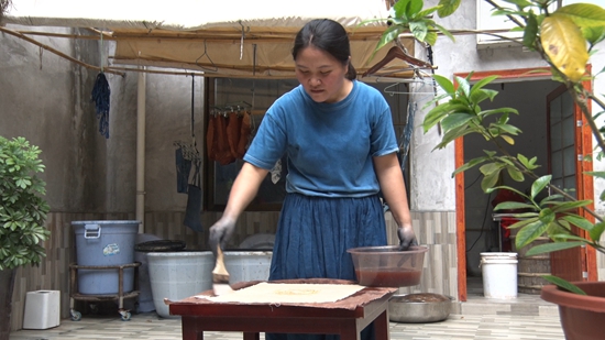 貴州丹寨：蠟染布上生花 鳥籠架間藏藝_fororder_蠟染縣級傳承人王永霞正在做柿染  徐鑫緣攝