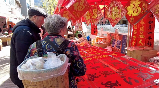 貴州盤州：物阜年豐 備年貨 喜迎新春_fororder_市民在古城年貨街選購對聯等