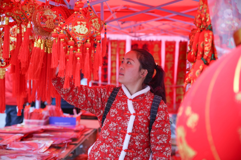 貴州施秉：春節近 年味濃_fororder_2024年2月5日，市民在貴州省黔東南苗族侗族自治州施秉縣城年貨集市上選購新春飾品。（磨桂賓 攝） (2).JPG