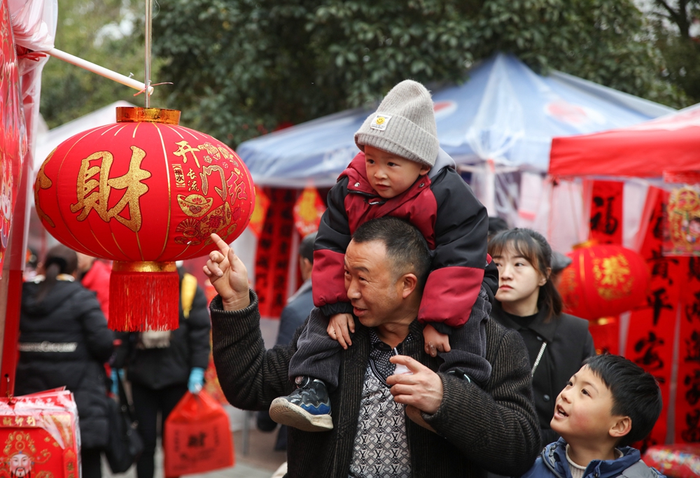 貴州施秉：春節近 年味濃_fororder_2024年2月5日，市民在貴州省黔東南苗族侗族自治州施秉縣城年貨集市上選購新春飾品。（磨桂賓 攝） (5).JPG