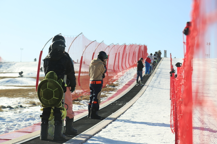 唐山市路北區第五屆冰雪運動會暨路北區第八屆冰雪節開幕_fororder_路北區第五屆冰雪運動會暨第八屆冰雪節開幕現場，現場，滑雪愛好者們乘自動扶梯前往雪坡頂端。 馬雅雄 攝 .JPG