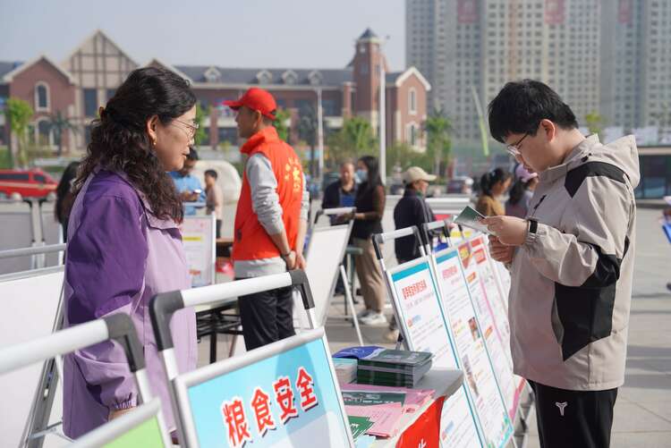 河北清苑：舉辦2024年全民國家安全教育日宣傳教育活動_fororder_市民觀看糧食安全宣傳手冊。攝影 王磊