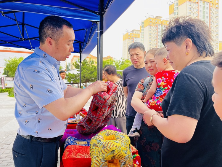 河北淶水：傳承非遺技藝 促進文化振興_fororder_圖為非遺傳承人正在向群眾介紹耳枕。（李金璐 攝）.JPG