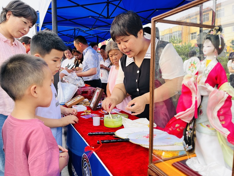 河北淶水：傳承非遺技藝 促進文化振興_fororder_圖為非遺傳承人正在向小朋友展示絹人的製作流程。（李金璐 攝）.JPG