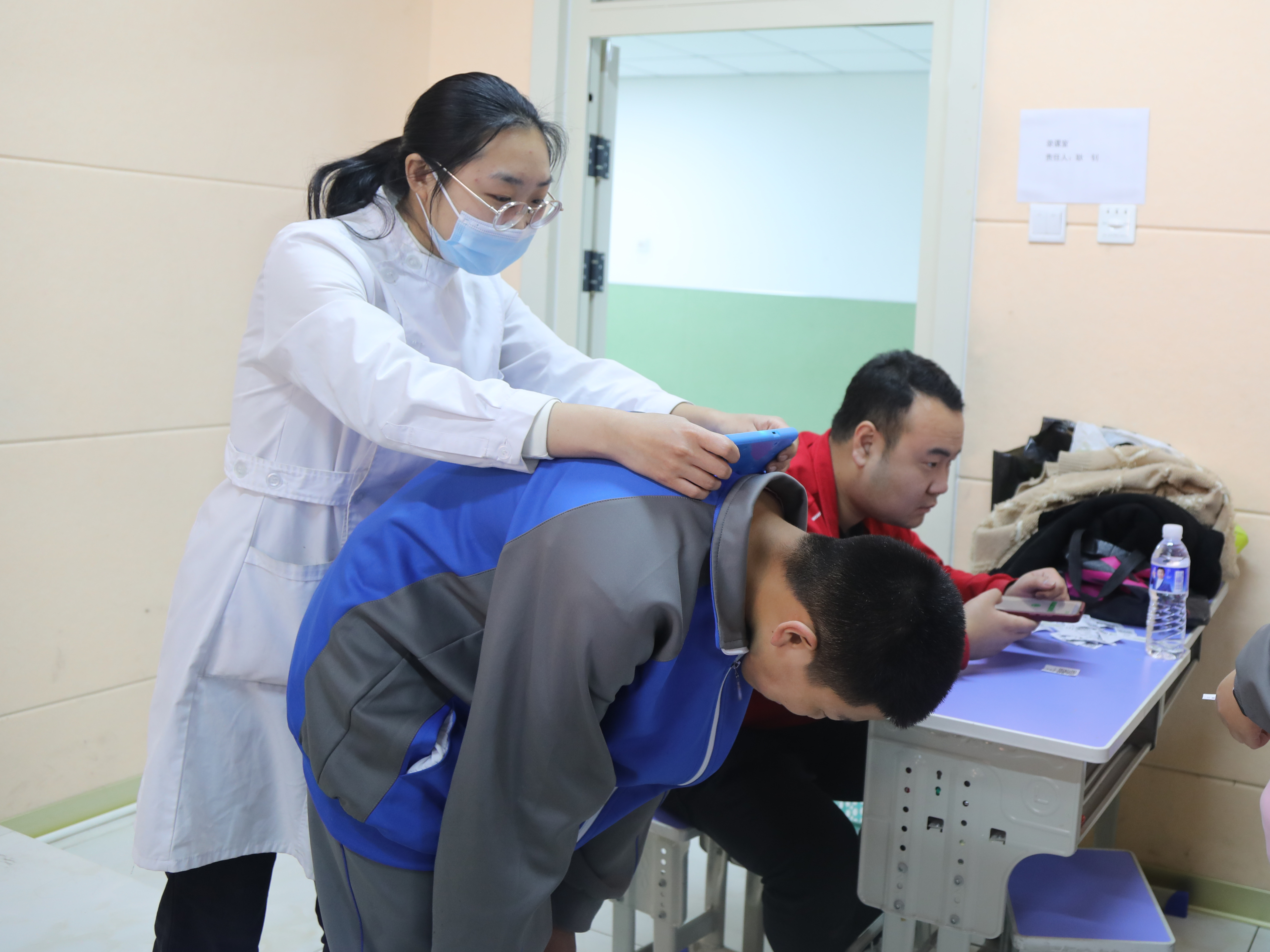 河北唐縣：數字化脊柱篩查護航學生成長_fororder_醫護人員正在給學生檢查2