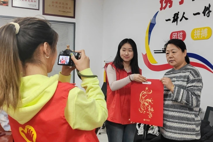 河北遷安：小城大愛 以青春之火點燃志願之光_fororder_圖為遷安青年志願者與居民同書春聯迎新春。 葛洪利攝