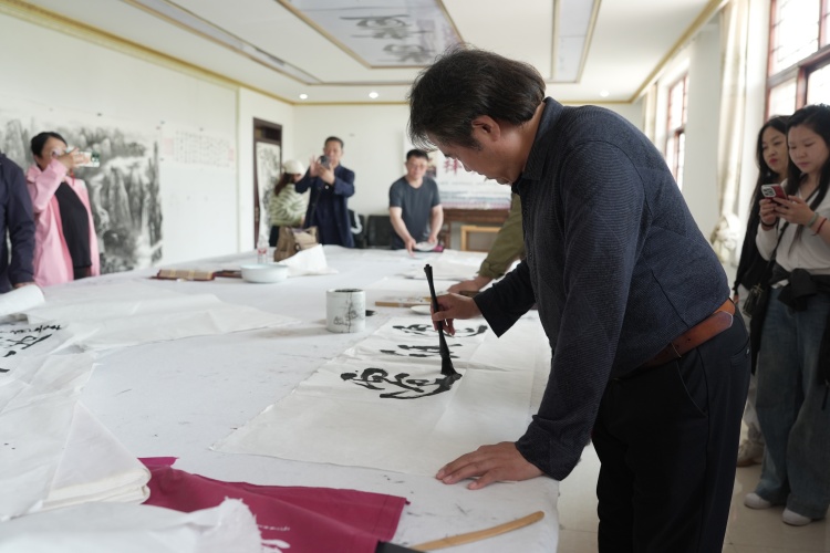 河北遷安：百名藝術家“遷紙”畫遷安_fororder_4月30日，藝術家正在用遷紙創作書法作品，張澤慧 攝
