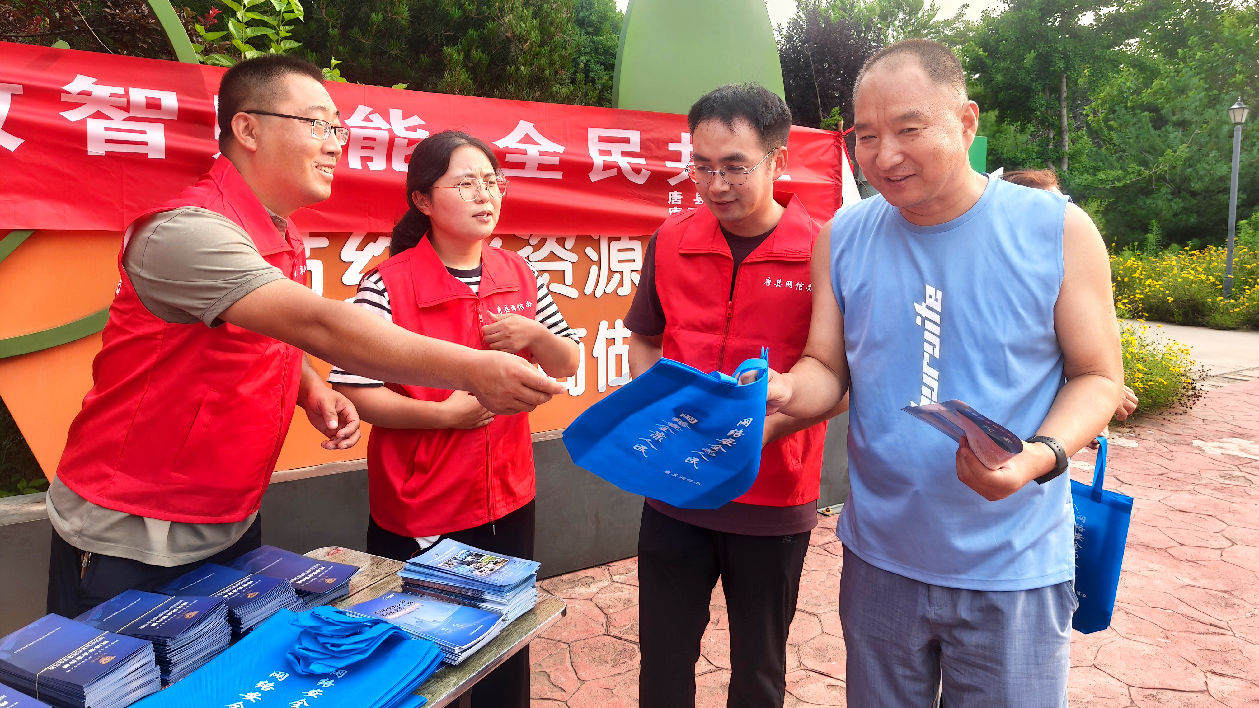 河北唐縣：開展“數智賦能 全民共享”主題宣傳進公園活動_fororder_工作人員發放宣傳資料和宣傳手袋