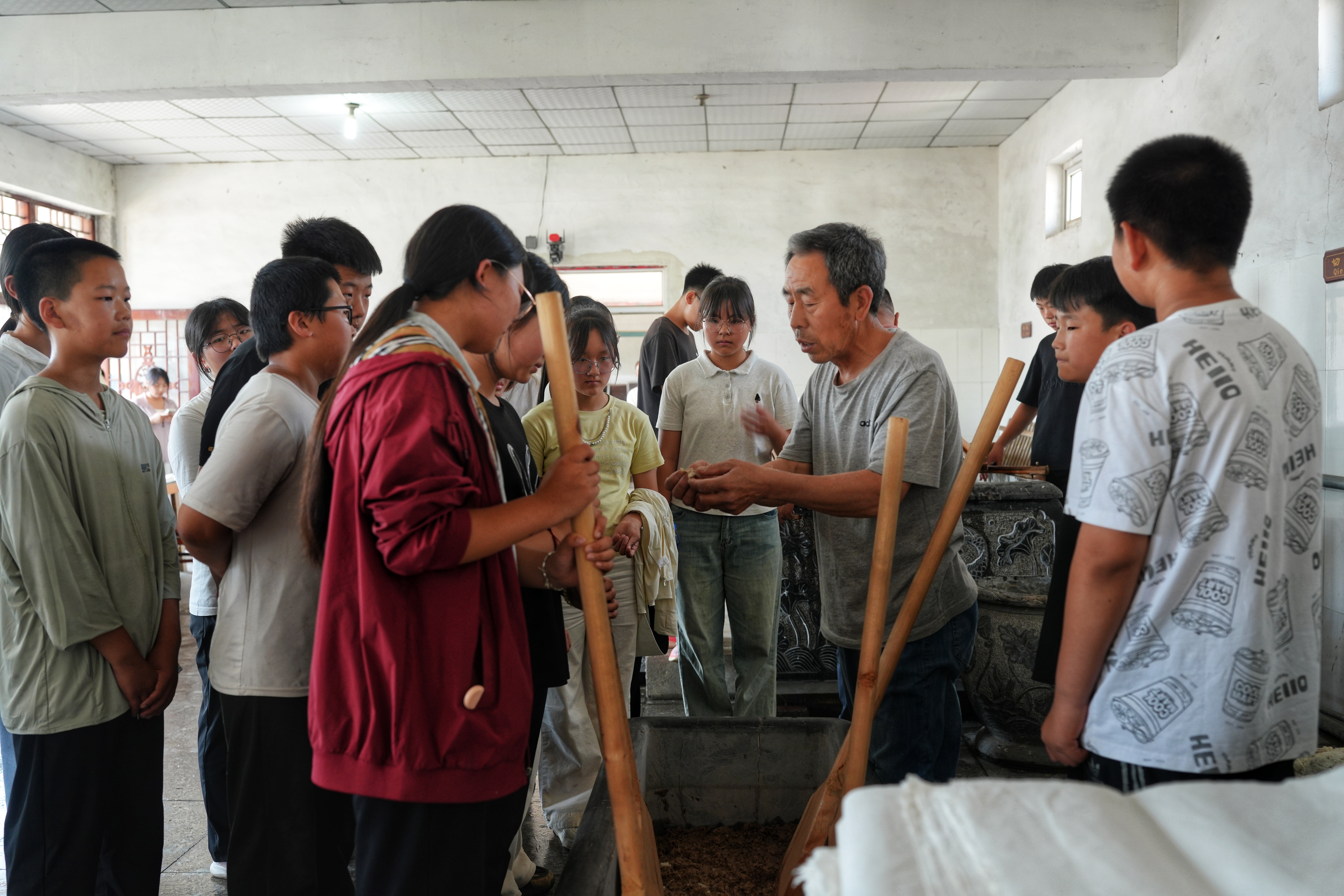 河北遷安：童心探非遺 遷紙傳薪火_fororder_近日，遷安市閻家店鎮完全小學學生正在體驗手工造紙搗堆工序。張澤慧攝