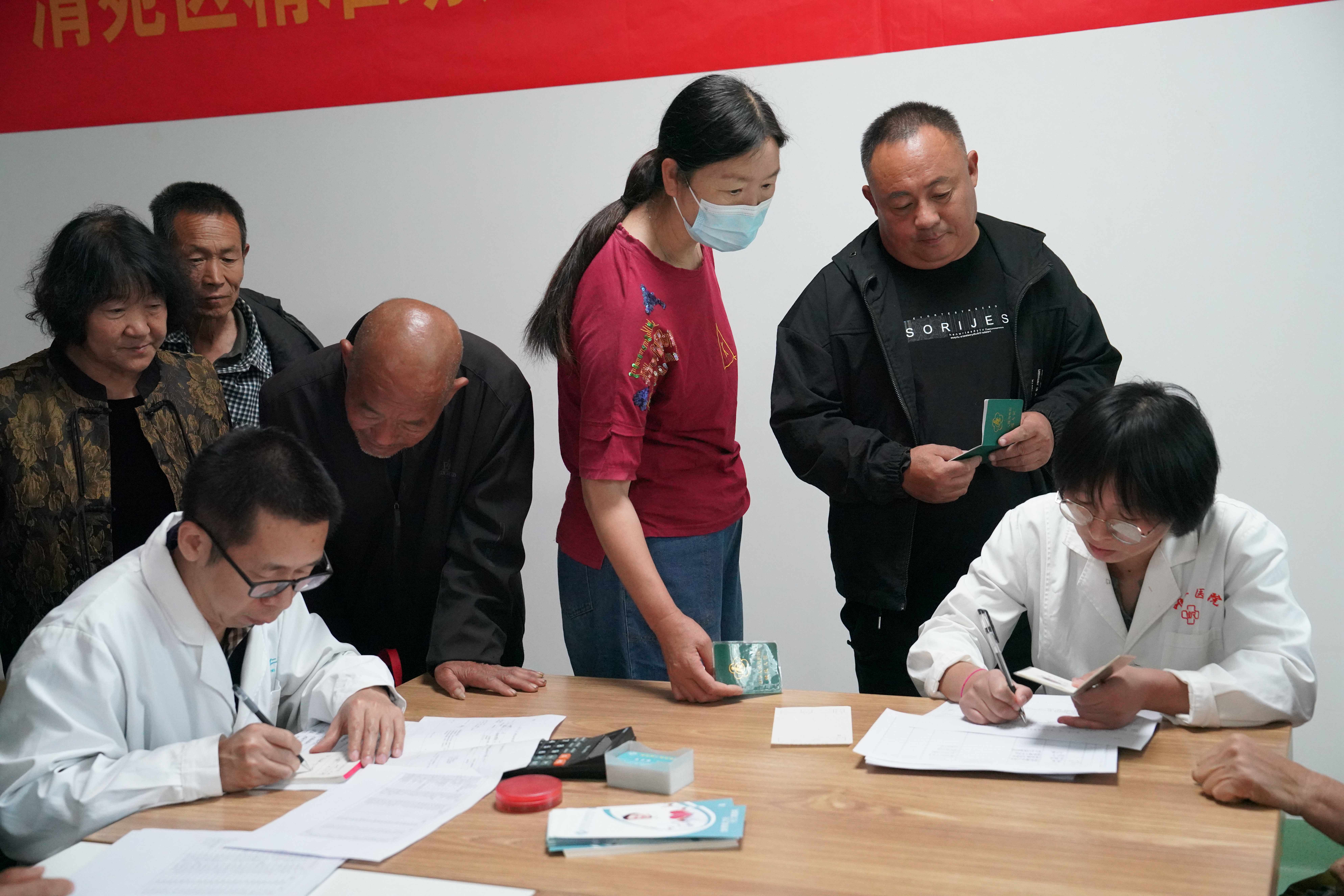 保定清苑：精準助殘 免費發藥暖民心_fororder_醫生詢問精神障礙患者家屬患者病情，為患者開處方。攝影 王磊