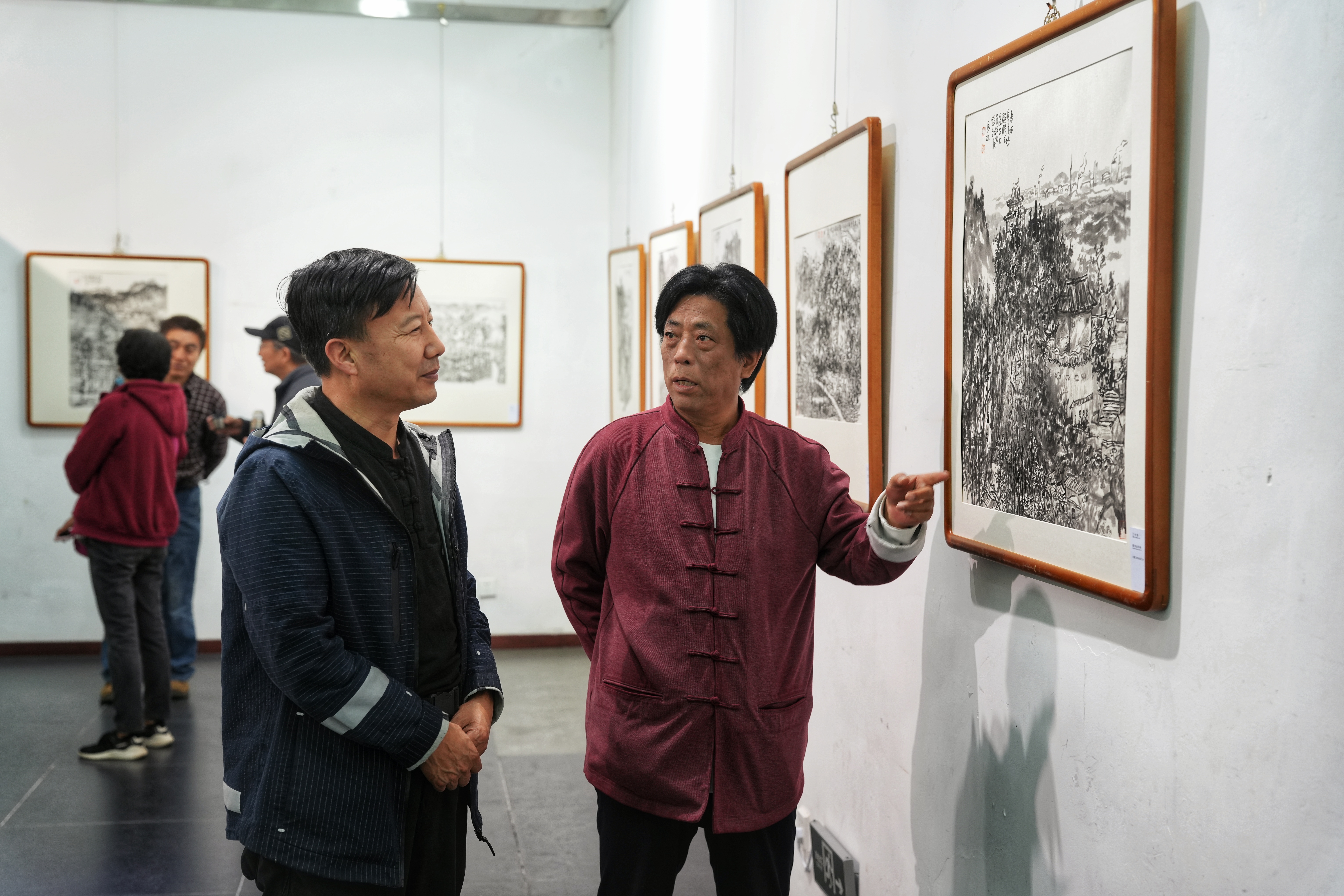 河北省遷安市“紙映長城韻 墨染遷安情”—“遷紙畫遷安”水墨長城鄉韻主題展開幕_fororder_5月9日，參展書畫家正在為市民講解畫作。張澤慧攝