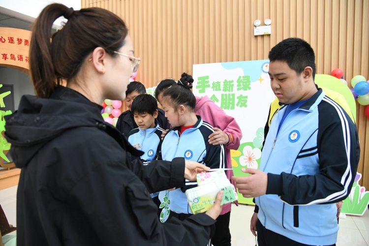 河北承德：綠意萌動 特殊孩子種下希望_fororder_圖為承德市特殊教育學校老師正在為啟音學生發放種子 張雨樵 攝.JPG