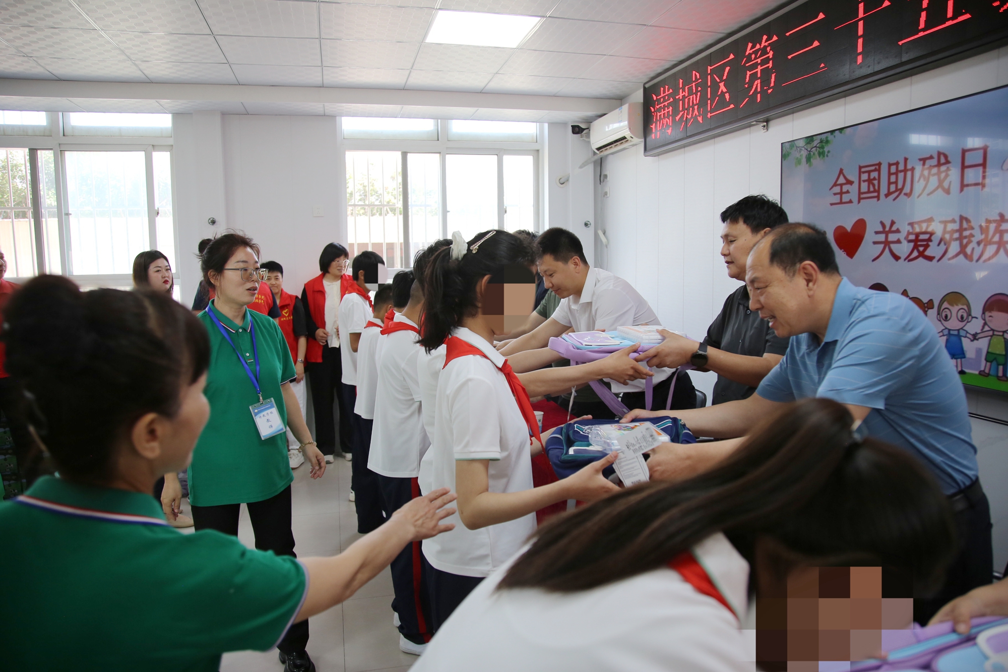 保定市滿城區：凝聚社會合力 共築助殘暖陽_fororder_出席活動的領導嘉賓向特教學生送上書包、營養品等物資 攝影 張辰澤