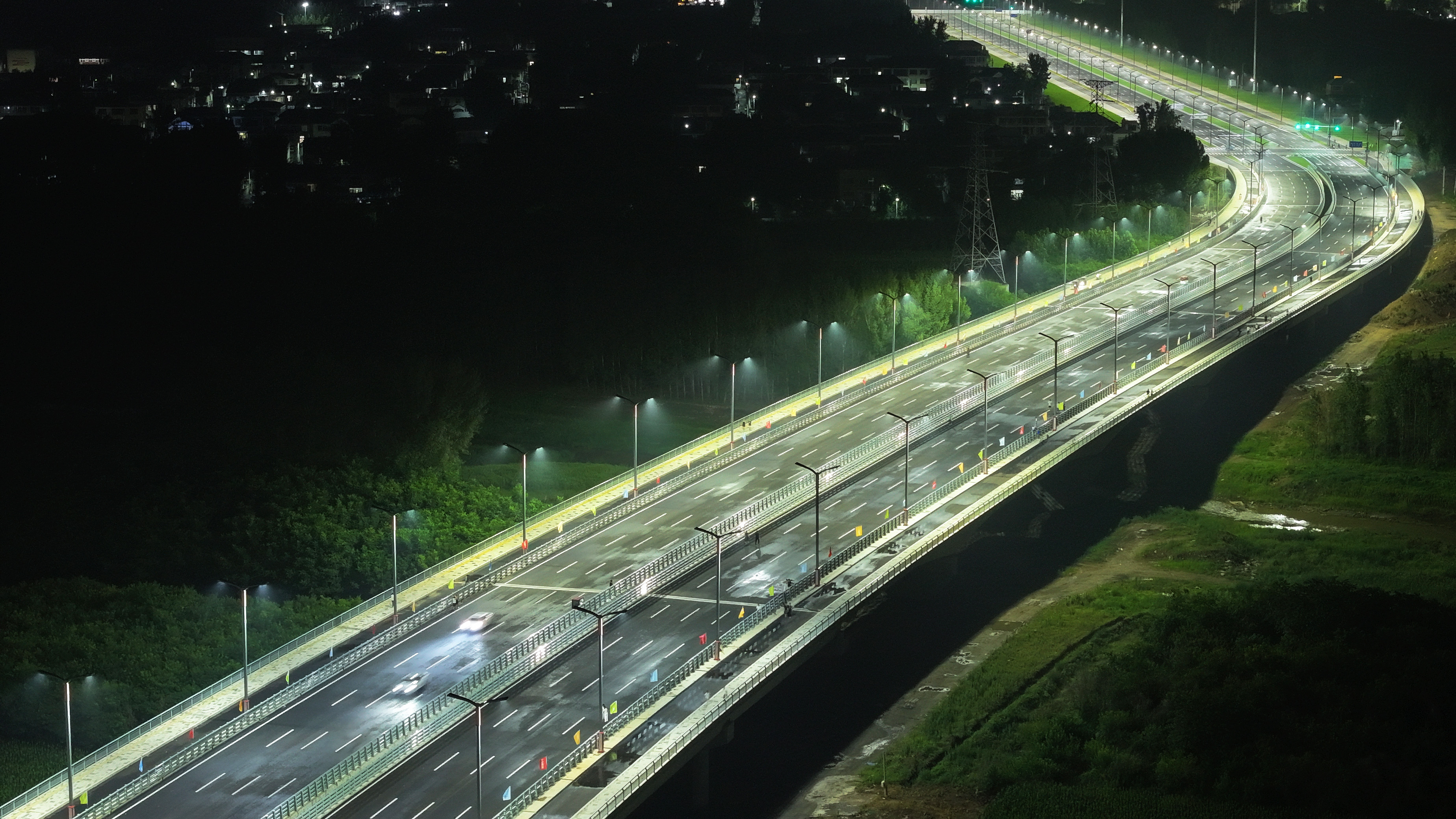 河北涿州：騰飛大街北延跨北拒馬河大橋建成通車_fororder_7月1日，河北省涿州市騰飛大街北延跨拒馬河大橋正式通車。圖為6月30日晚，車輛在大橋上試行（航拍照片）。熊華明攝
