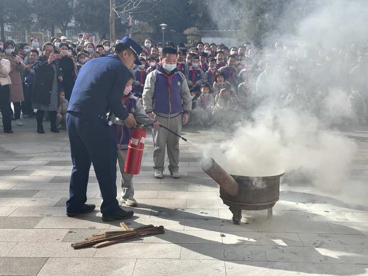 圖片默認標題_fororder_滿城區消防大隊隊員現場指導孩子滅火方法。劉朋 攝